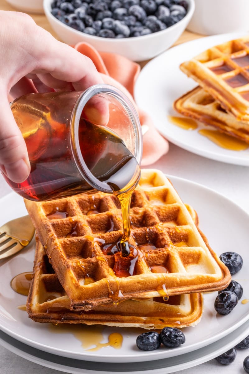 pouring syrup onto waffles