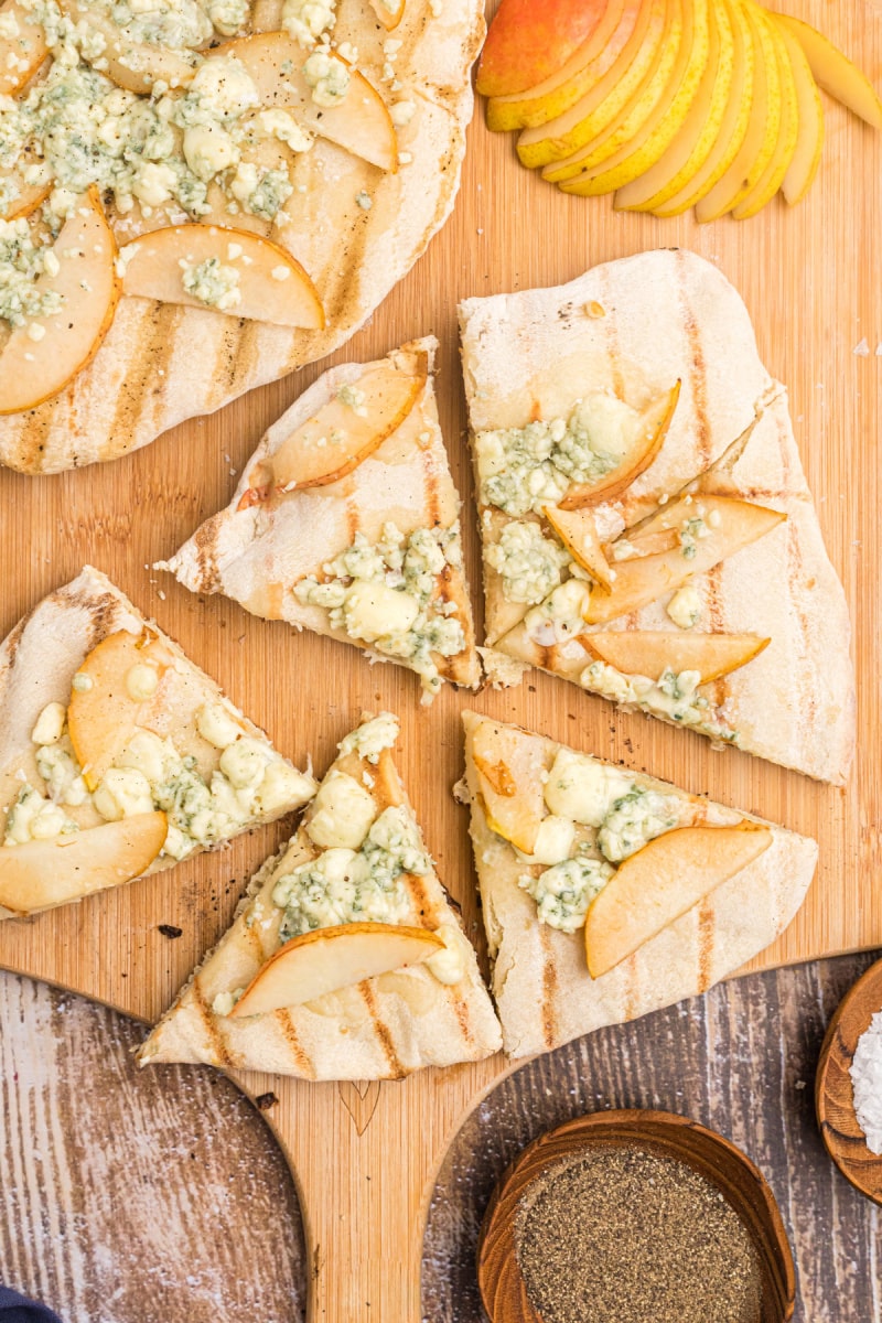 grilled blue cheese and pear pizza sliced on board