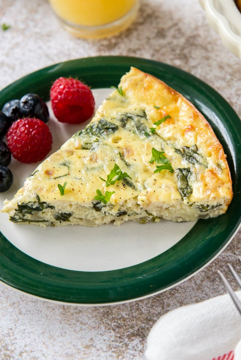 slice of spinach and cheese quiche on a plate