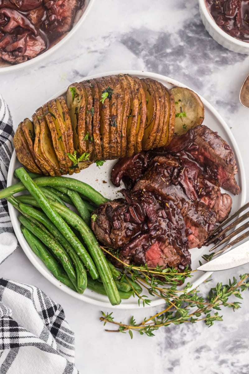 filet mignon with mushroom cabernet sauce on plate with potato and green beans