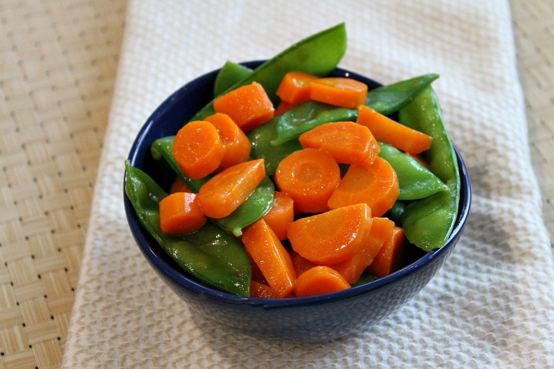Honey Glazed Pea Pods and Carrots recipe from RecipeGirl.com #honey #glazed #honeyglazed #peapods #carrots #recipe #RecipeGirl Bowl of Honey Glazed Pea Pods and Carrots