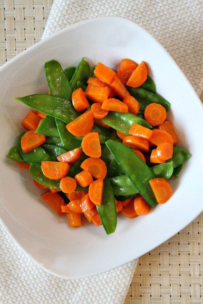 Honey Glazed Pea Pods and Carrots recipe from RecipeGirl.com #honey #glazed #honeyglazed #peapods #carrots #recipe #RecipeGirl Bowl of Honey Glazed Pea Pods and Carrots
