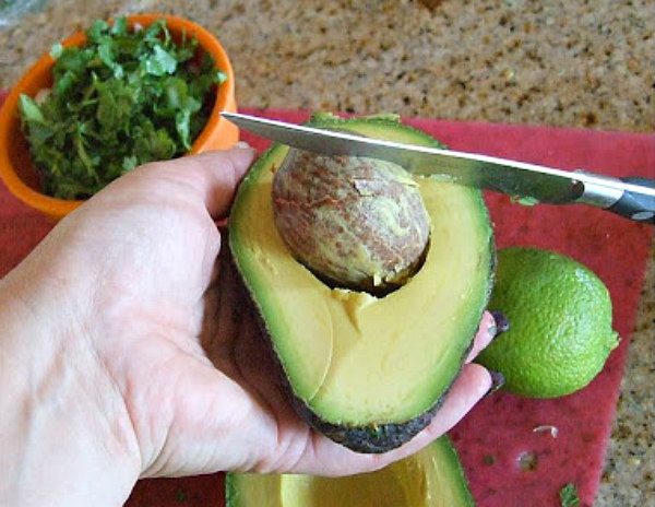 Mango Guacamole recipe from RecipeGirl.com #mango #guacamole #recipe #RecipeGirl knife removing pit from avocado
