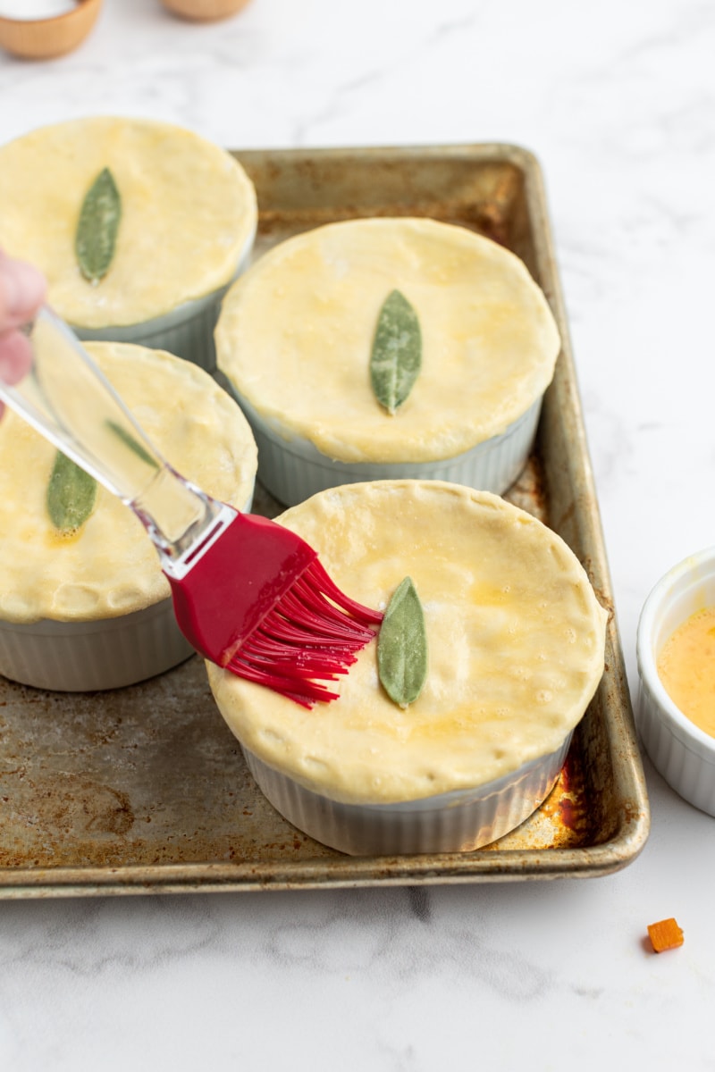 brushing egg wash onto pot pies