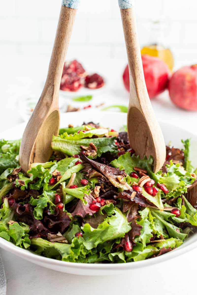 tossing mixed greens pomegranate salad