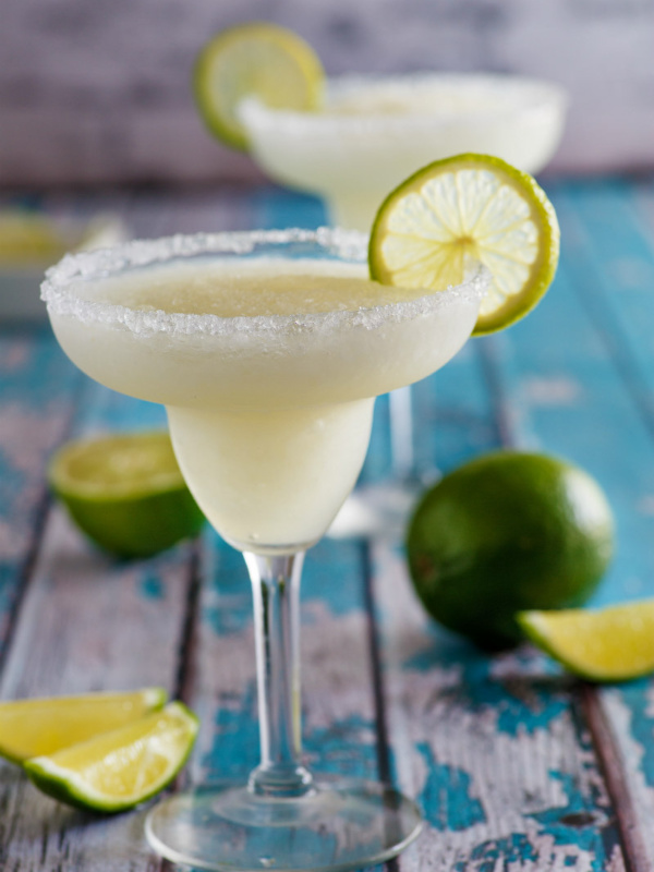 mock margaritas in margarita glasses. fresh lime garnish and wedges on display too