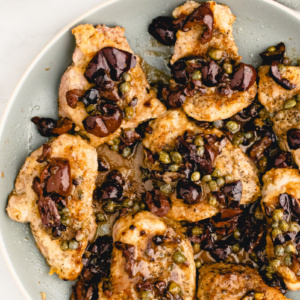 plate of pork with olives and capers