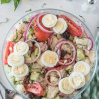 bowl of potato salad with olives tomatoes and capers