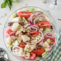 bowl of potato salad with olives tomatoes and capers