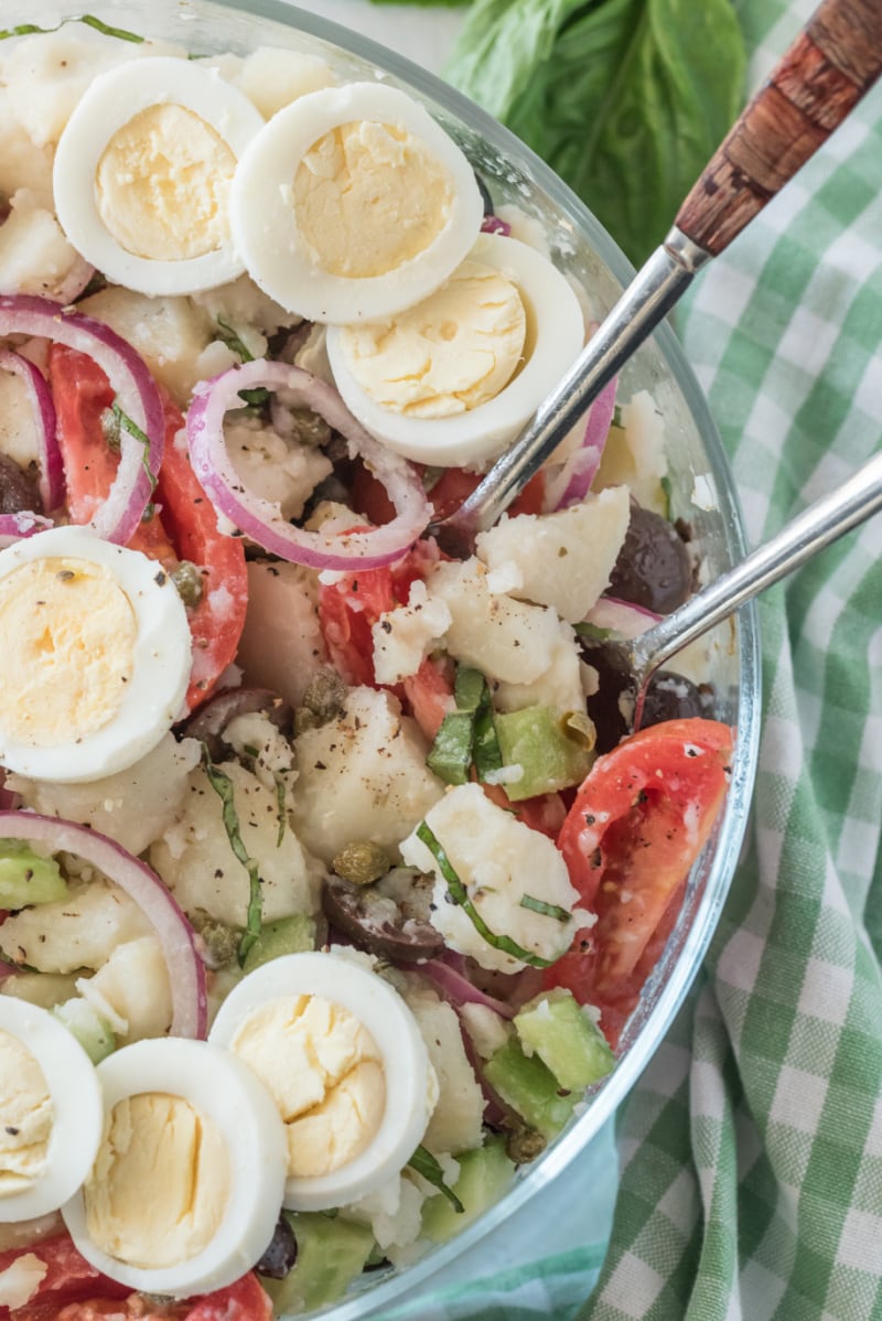 bowl of potato salad with olives tomatoes and capers