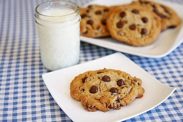 Reeses Stuffed Peanut Butter Chocolate Chip Cookies recipe from RecipeGirl.com #reeses #peanutbuttercup #peanutbutter #stuffed #chocolatechip #cookies #recipe #RecipeGirl Reeses Stuffed Peanut Butter Chocolate Chip Cookies with a glass of milk