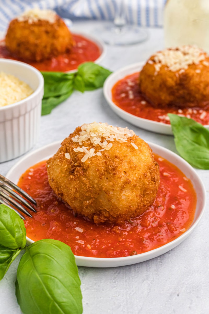 risotto croquette set on plate of marinara sauce