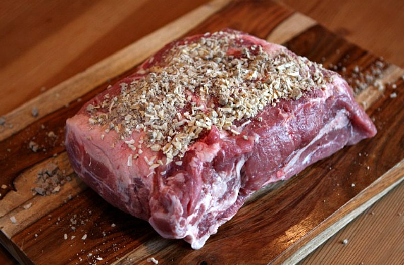 pork roast on a cutting board, topped with spices