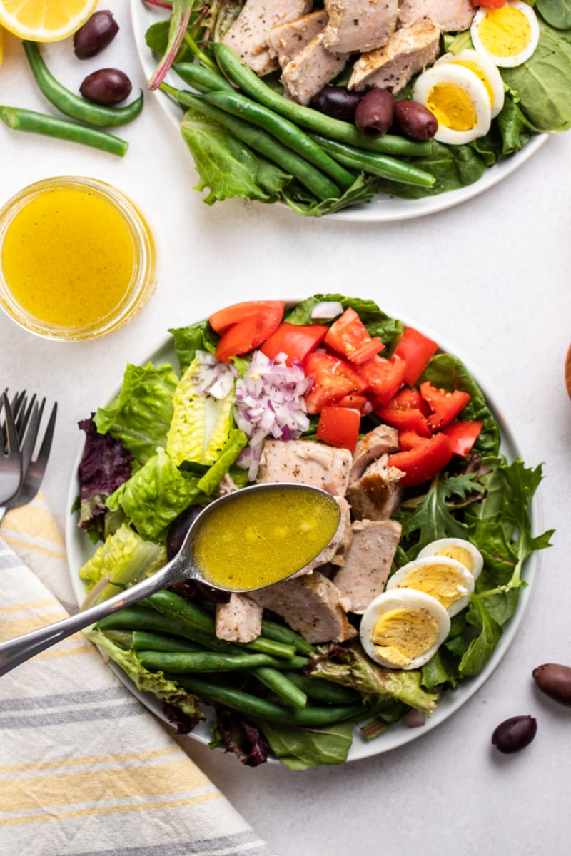 spooning dressing onto salad