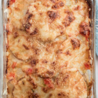 scalloped potatoes with peppers and swiss cheese in baking dish