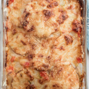 scalloped potatoes with peppers and swiss cheese in baking dish