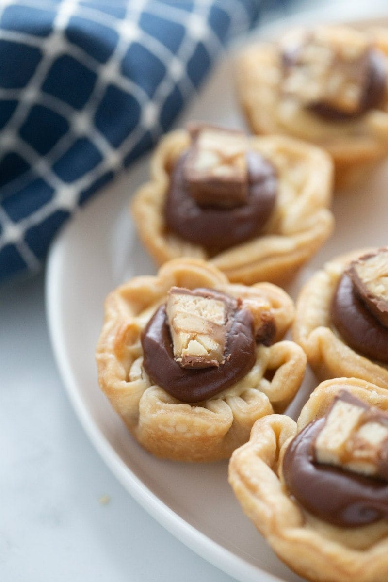 snickers bar mini tarts on a white platter