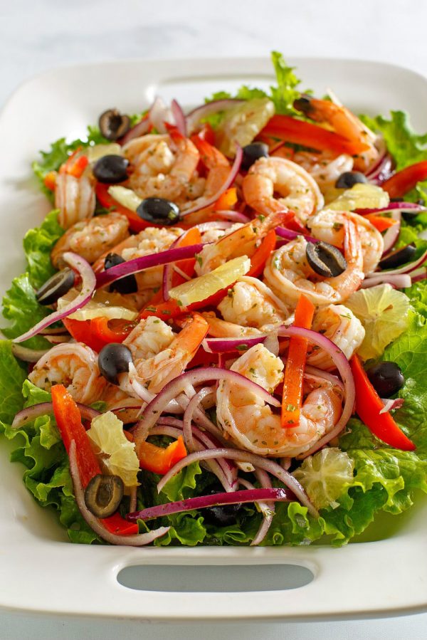 Spicy Lemon Shrimp Salad on a white platter edged with lettuce leaves