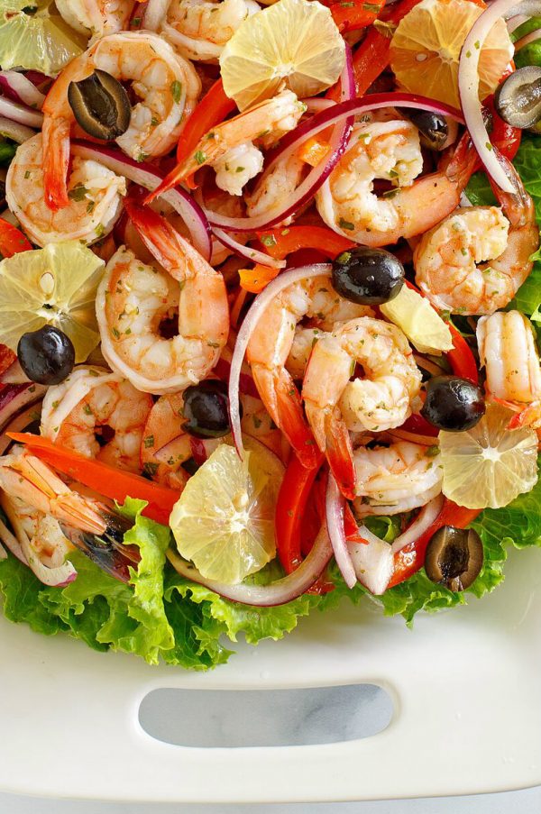 Spicy Lemon Shrimp Salad on a white platter edged with lettuce leaves