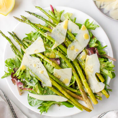 spring lettuce salad on a plate with asparagus and parmesan