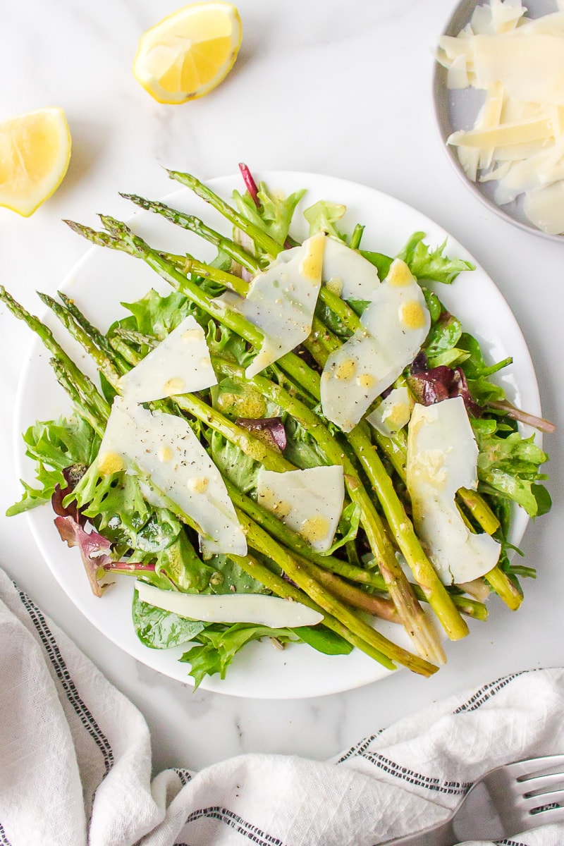 spring lettuce salad on a plate with asparagus and parmesan