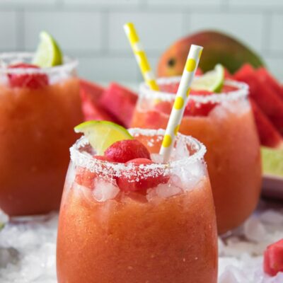 watermelon mango margaritas with yellow straws and lime garnishes