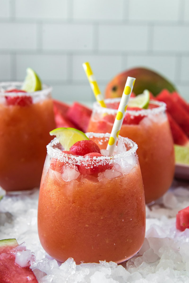 watermelon mango margaritas with yellow straws and lime garnishes