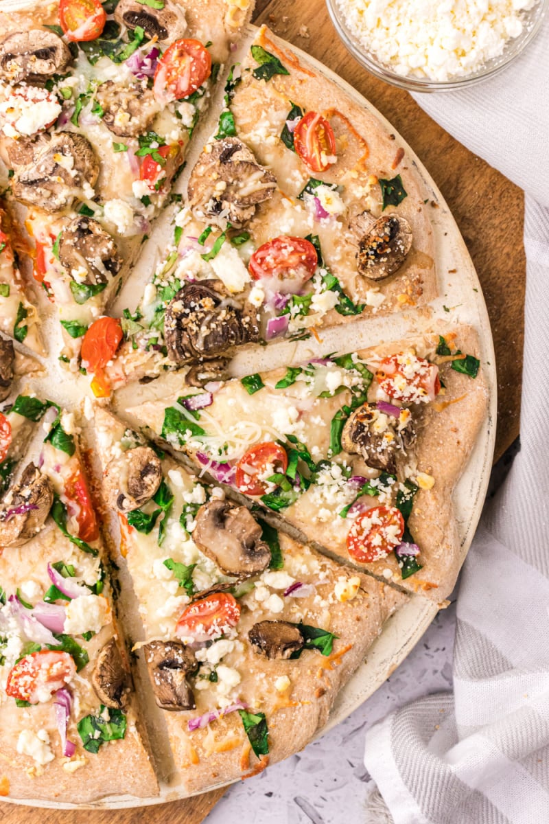 spinach mushroom and feta pizza cut into slices