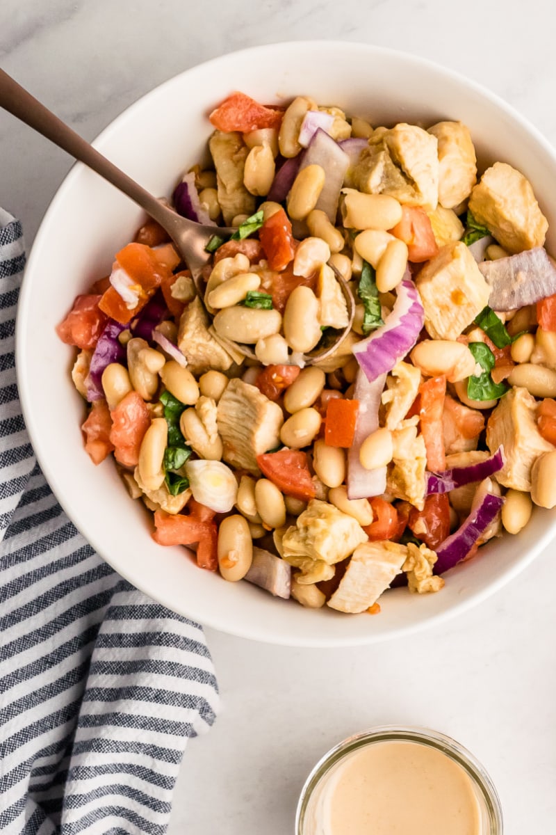 White Bean and Roasted Chicken Salad recipe from RecipeGirl.com #whitebeans #cannellini #beans #roastedchicken #rotisseriechicken #chicken #salad #recipe #RecipeGirl white bowl of white bean and roasted chicken salad
