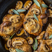 chicken marsala garnished with fresh sage in a skillet