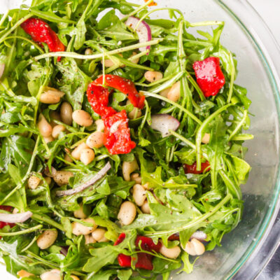 arugula, white bean and roasted red pepper salad in a bowl