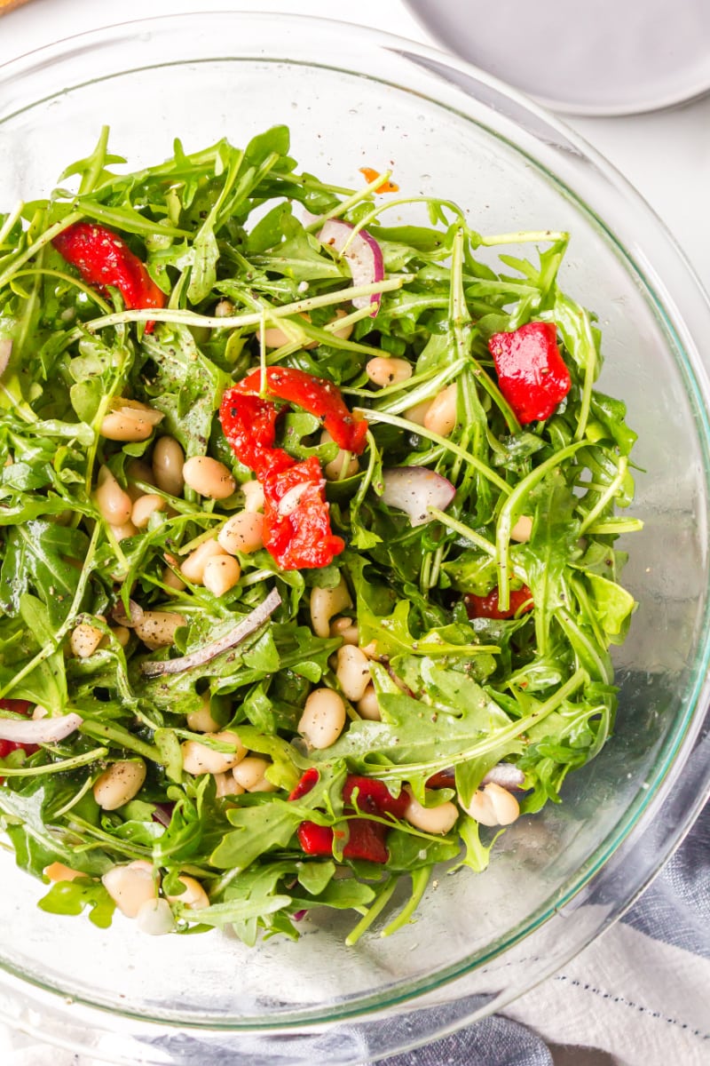 arugula, white bean and roasted red pepper salad in a bowl