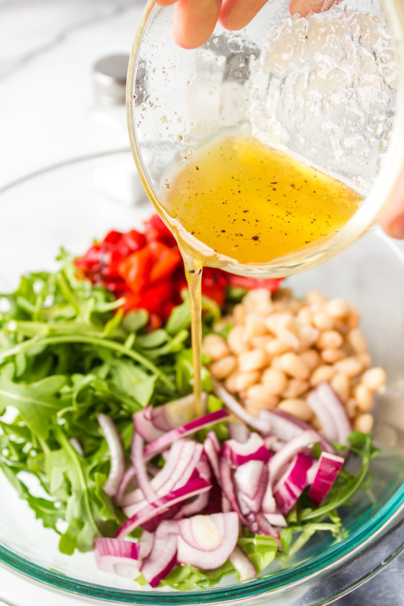 pouring dressing onto salad