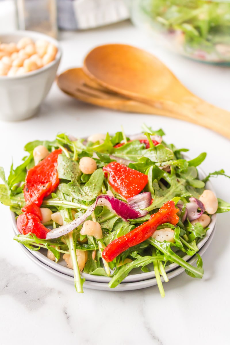 arugula, white bean and roasted red pepper salad on a plate