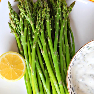 asparagus with caper dill sauce on a platter