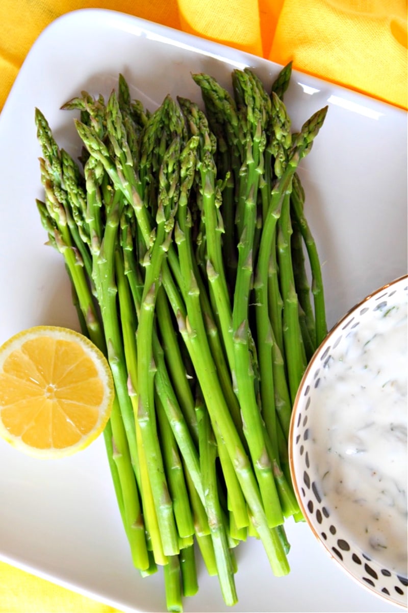 asparagus with caper dill sauce on a platter