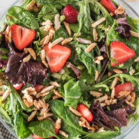 green salad with strawberries and sugared almonds