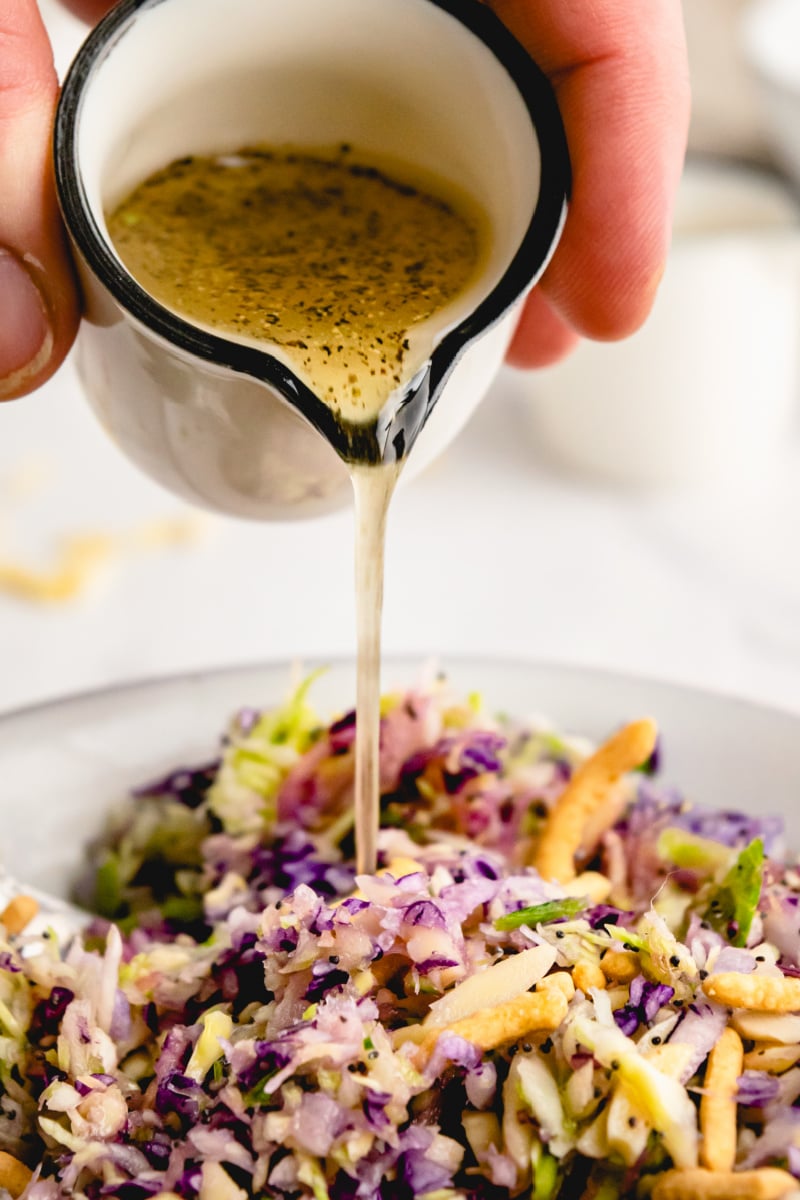 dressing being poured onto salad