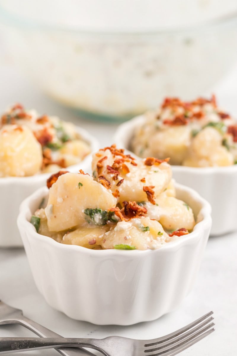 single servings of blue cheese and bacon potato salad in white bowls