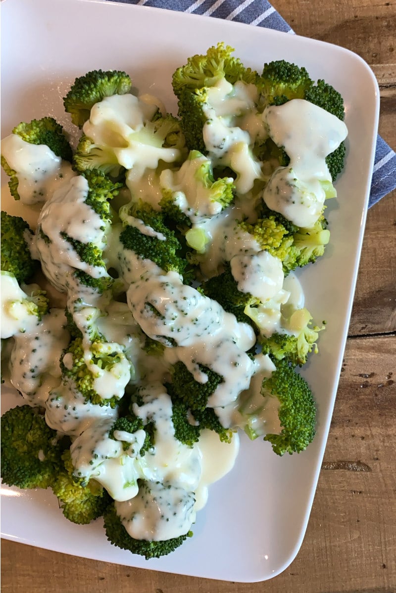 Broccoli with Cheddar Cheese Sauce recipe from RecipeGirl.com #broccoli #cheddar #cheese #sauce #recipe #RecipeGirl broccoli on a plate with cheese sauce