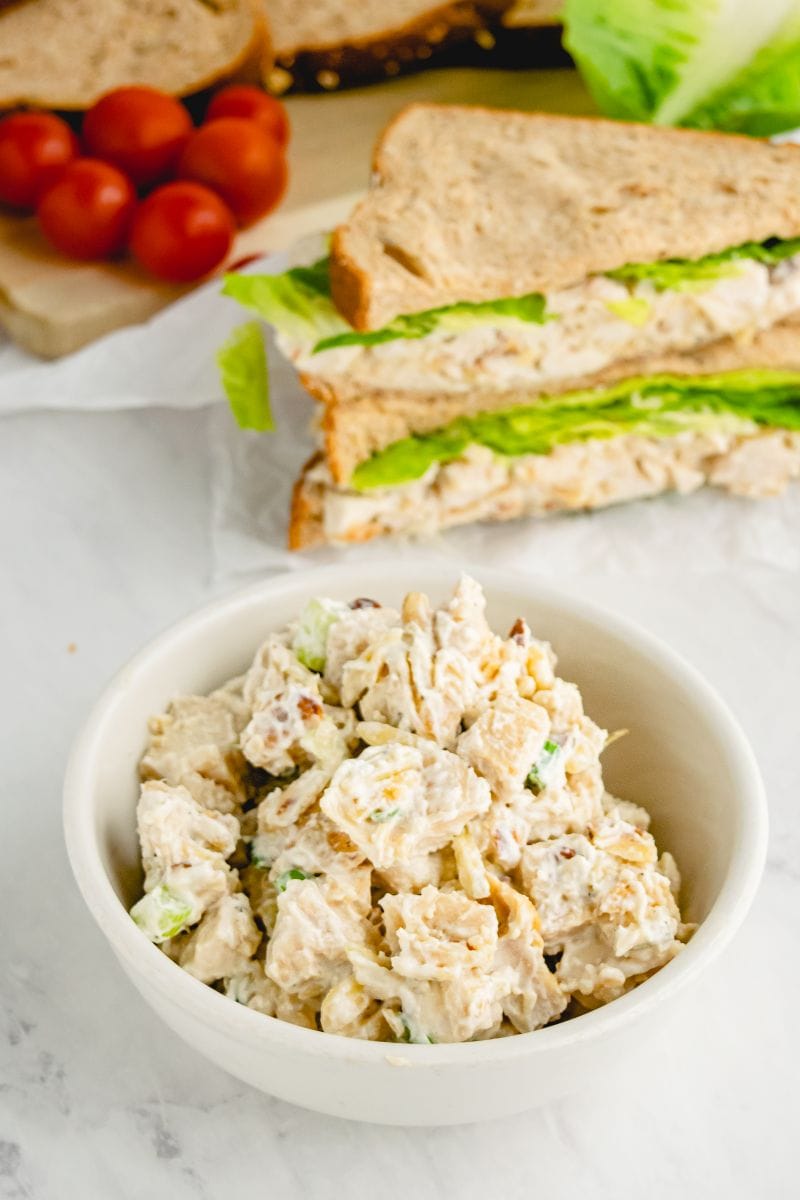 chicken almond salad in bowl with sandwich in background