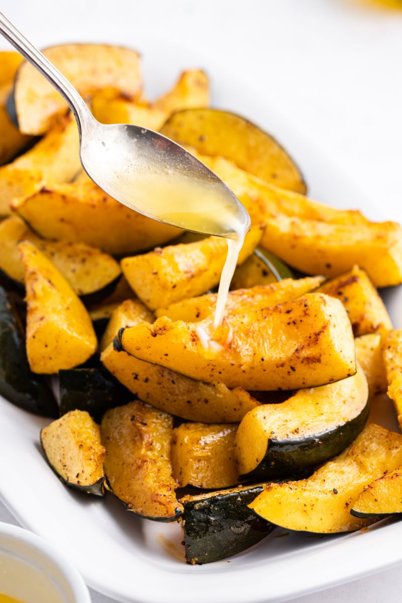 spooning butter onto roasted acorn squash