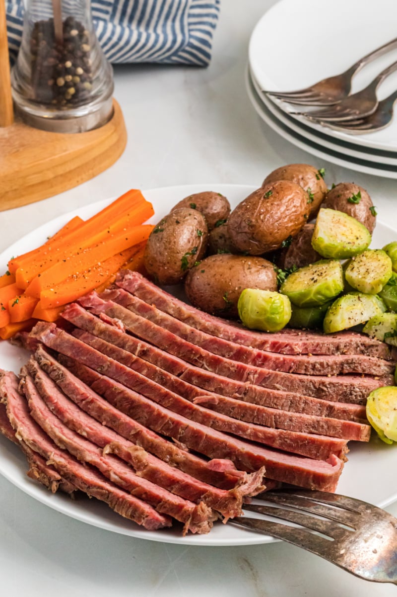 Classic Corned Beef recipe from RecipeGirl.com #classic #cornedbeef #recipe #RecipeGirl sliced corned beef on a plate with veggies