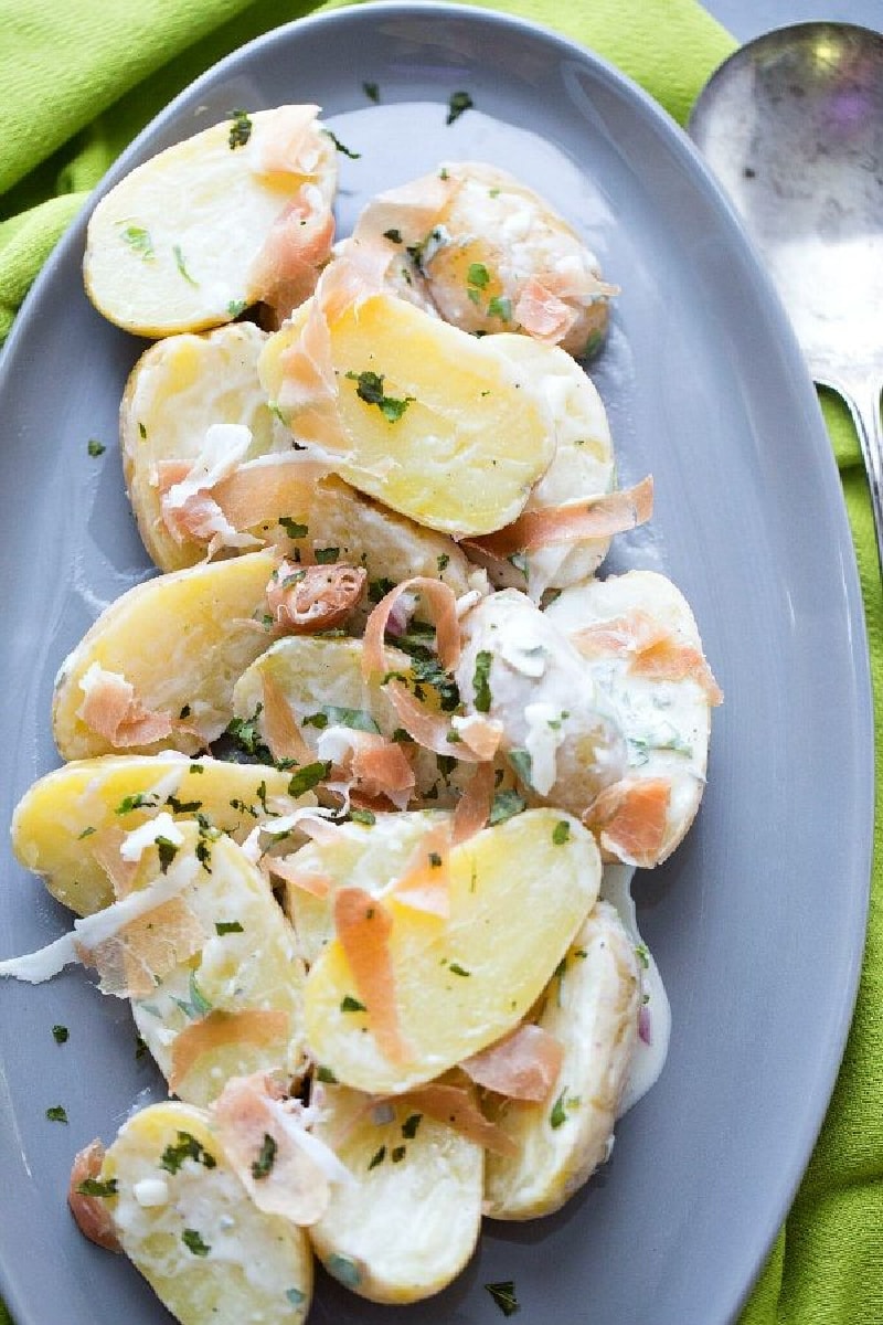 Fingerling Potato and Prosciutto Salad recipe from RecipeGirl.com #fingerlingpotatoes #prosciutto #salad #recipe #RecipeGirl fingerling potato and prosciutto salad on a blue plate