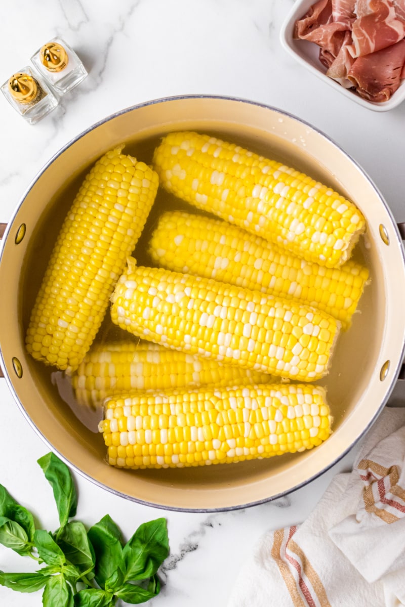 corn on the cobs in a pot of water