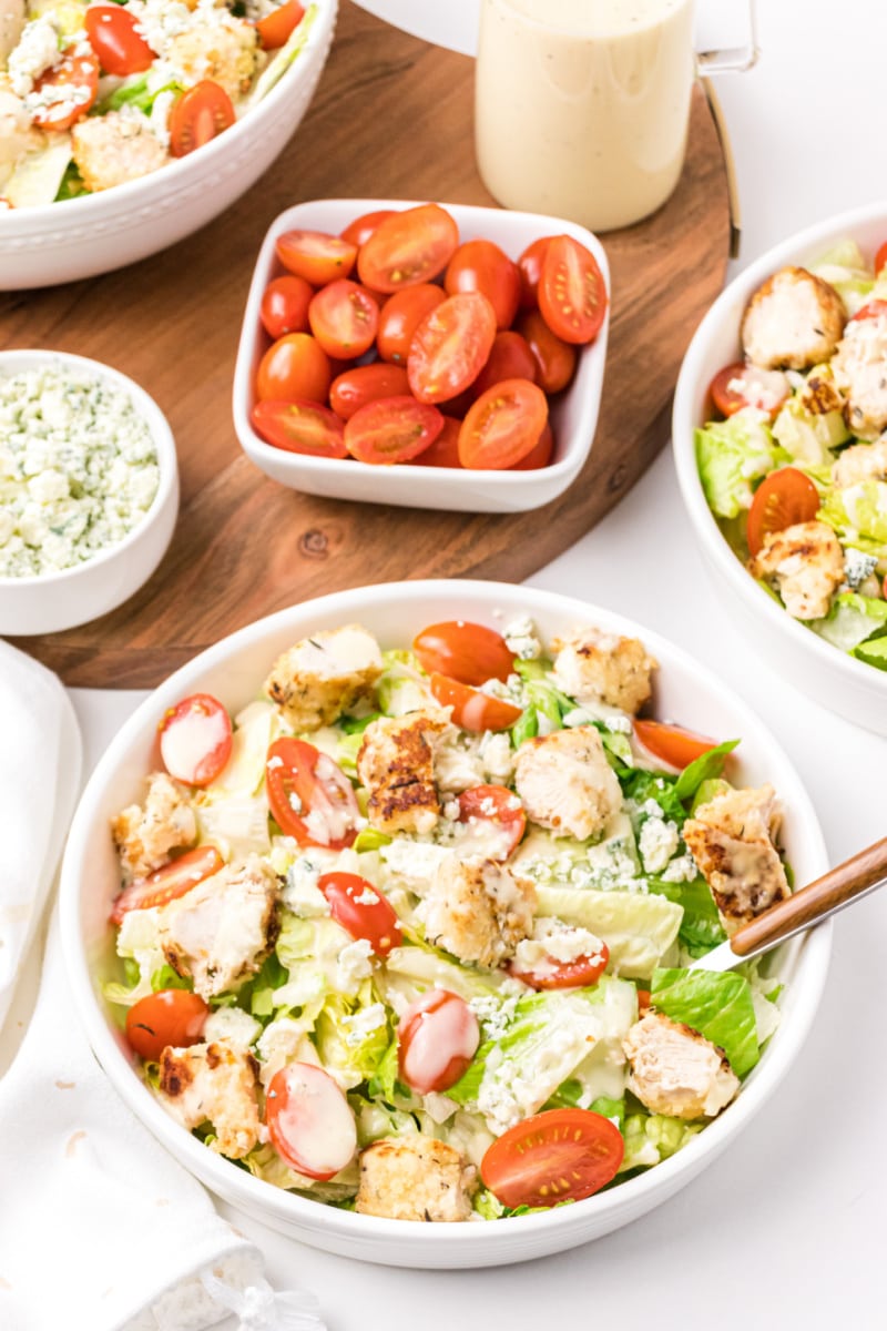 fried chicken salad with tomatoes in background