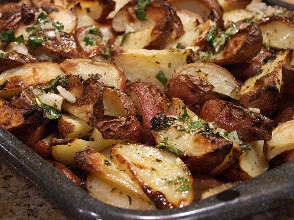 greek potatoes with lemon vinaigrette on a baking sheet