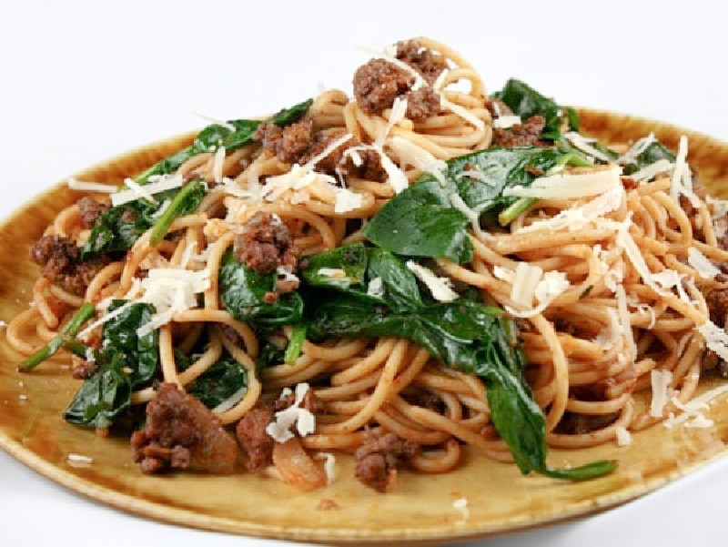 lamb spaghetti with spinach on a plate