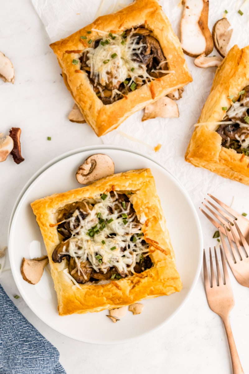 mushroom and cheese tart on a white plate with a fork