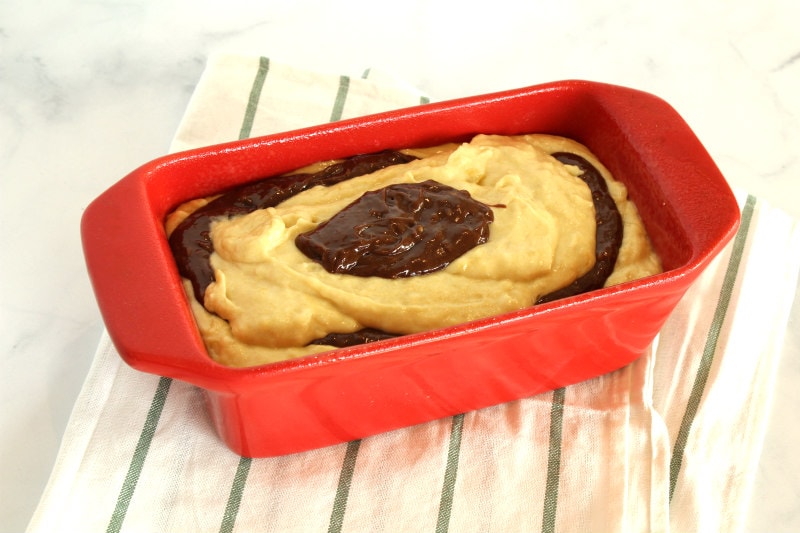 chocolate and banana batter in a red loaf pan